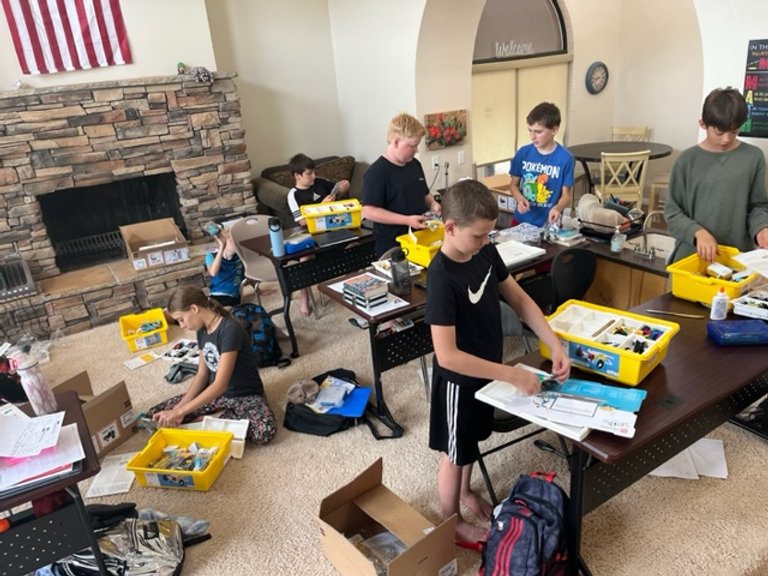 A group of children diligently working on their projects in a room, showcasing their creativity and teamwork.