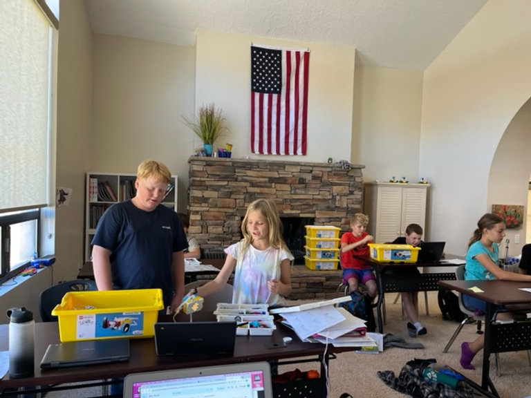 A classroom filled with children diligently working on their laptops, engaged in their studies.